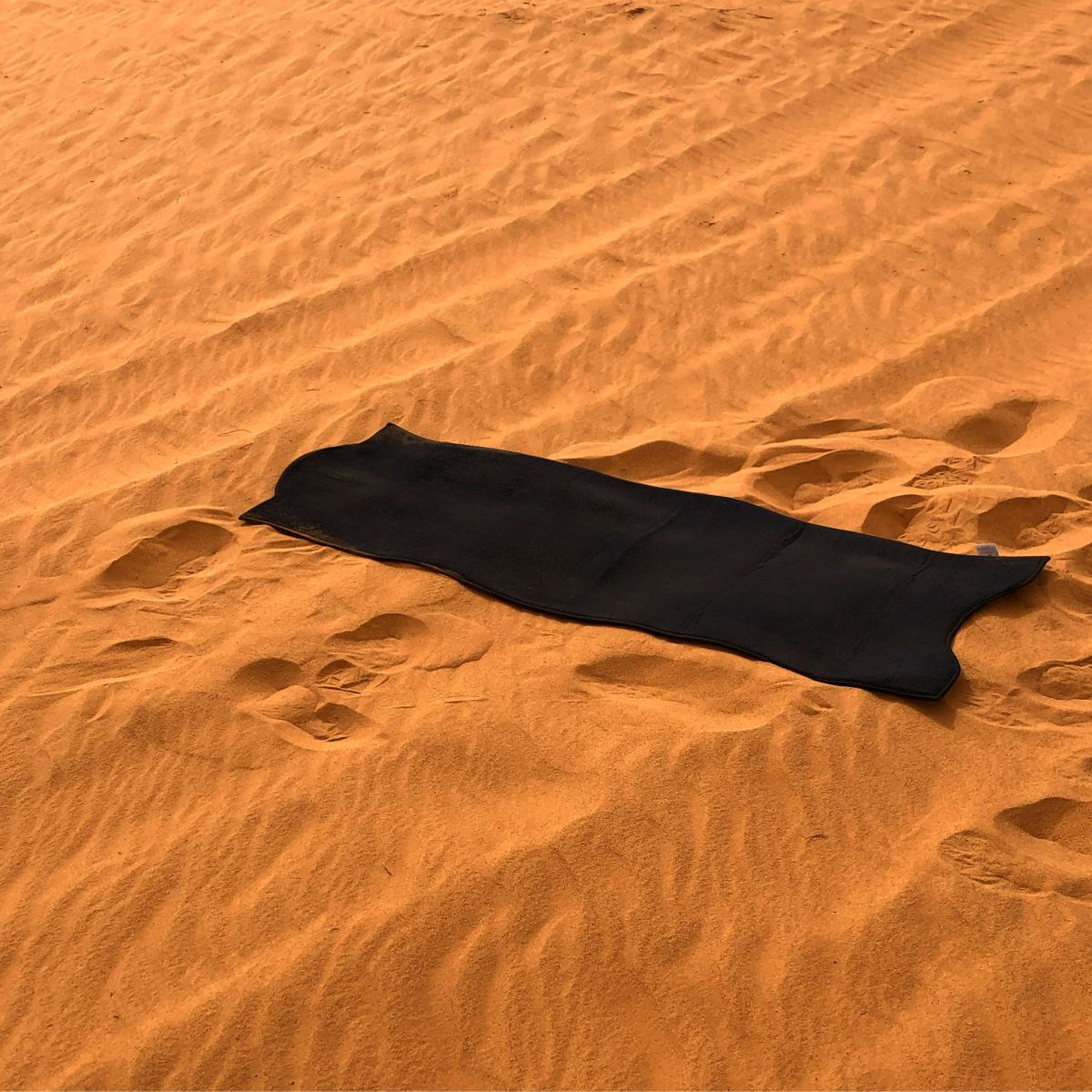Les tapis de prière épais Sajada-Souleyman sur un sol en sable, au désert